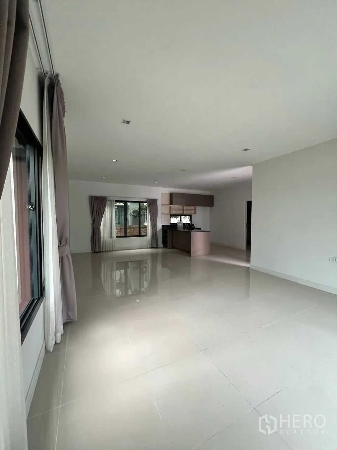 Detached House for rent in Bang Phli, Samut Prakan - Open-plan living and dining area with glossy tiled floors and sliding glass doors.