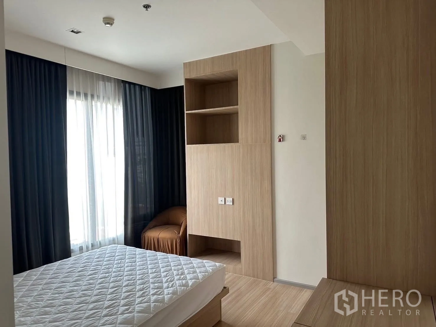 公寓 出租在Chatuchak, Bangkok - 卧室一角的内置衣柜与搁架，旁有全高窗帘。