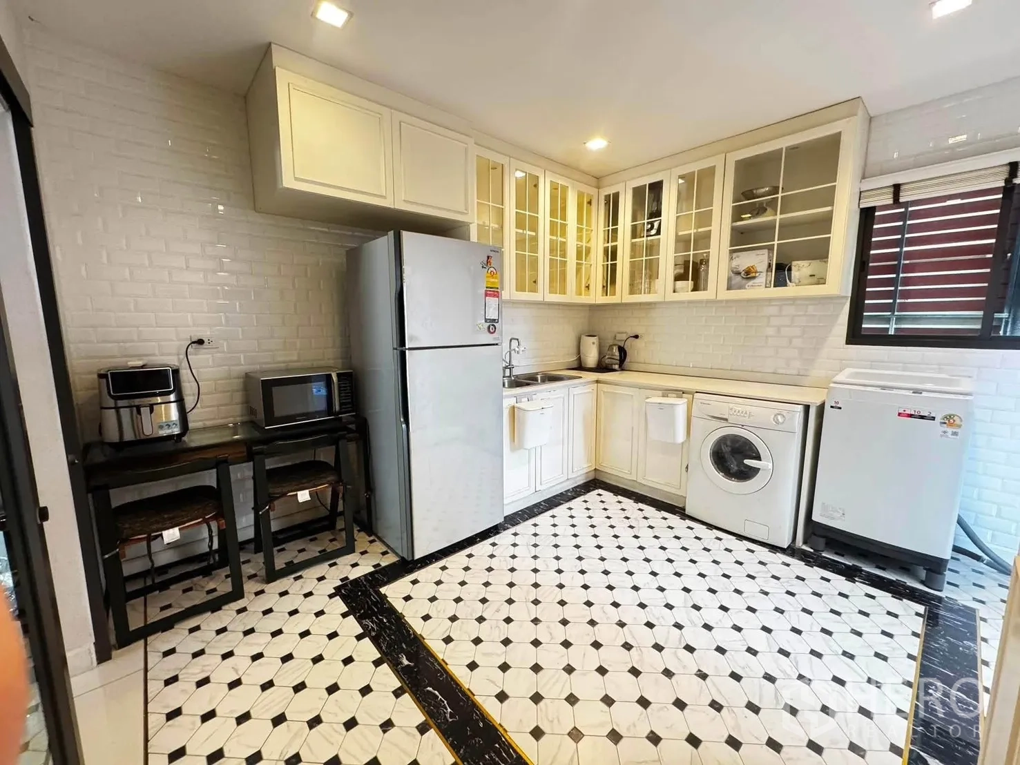 Detached House for rent in Saphan Sung, Bangkok - Kitchen with white cabinets, tiled backsplash, patterned floor, and appliances.
