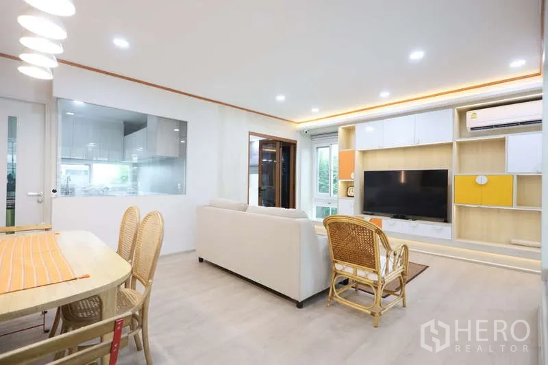 独立式住宅 出租或出售在Prawet, Bangkok - 起居餐厅视角，带玻璃隔断的厨房与推拉门。