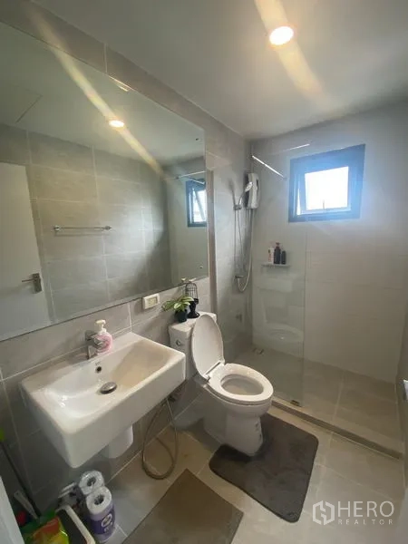 Detached House for rent in Bang Phli, Samut Prakan - Clean bathroom with glass shower enclosure, large mirror, sink and toilet.