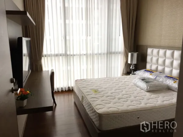 公寓 出租在Watthana, Bangkok - 卧室配大窗户与纱帘，墙面书桌与柔和采光。
