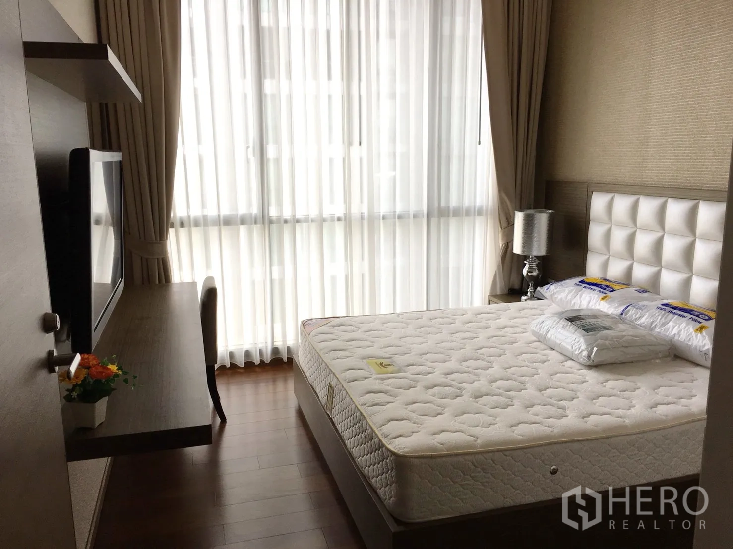 公寓 出租在Watthana, Bangkok - 卧室配大窗户与纱帘，墙面书桌与柔和采光。