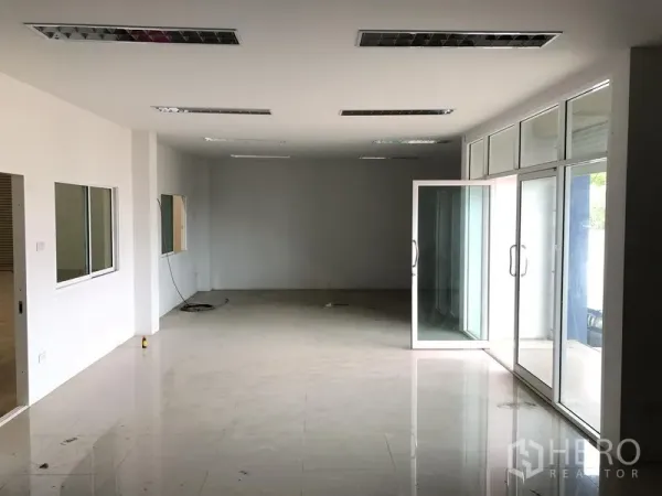 Factory for rent or sale in Bang Sao Thong, Samut Prakan - Ground-floor office area with glass frontage, tiled floors, and fluorescent lighting.