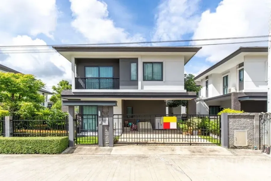 บ้าน ให้เช่าในBang Phli, Samut Prakan - บ้านเดี่ยวสองชั้นสมัยใหม่ หน้าบ้านมีกำแพงรั้ว ระเบียง และที่จอดรถมีหลังคา