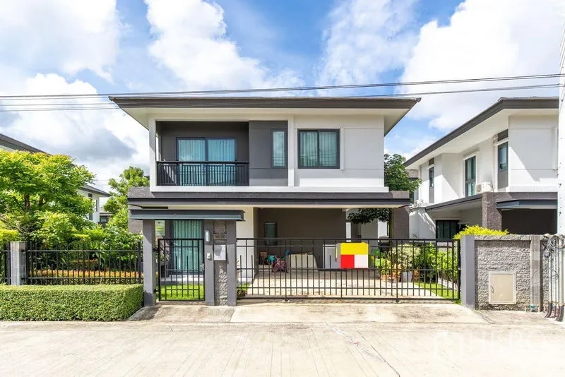 บ้าน ให้เช่าในBang Phli, Samut Prakan - บ้านเดี่ยวสองชั้นสมัยใหม่ หน้าบ้านมีกำแพงรั้ว ระเบียง และที่จอดรถมีหลังคา