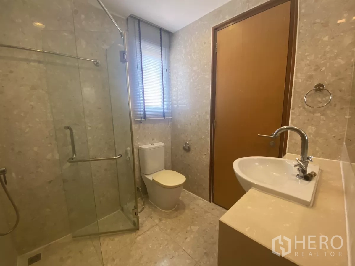 Condominium for rent in Watthana, Bangkok - Guest bathroom with glass shower enclosure, toilet and window for ventilation.