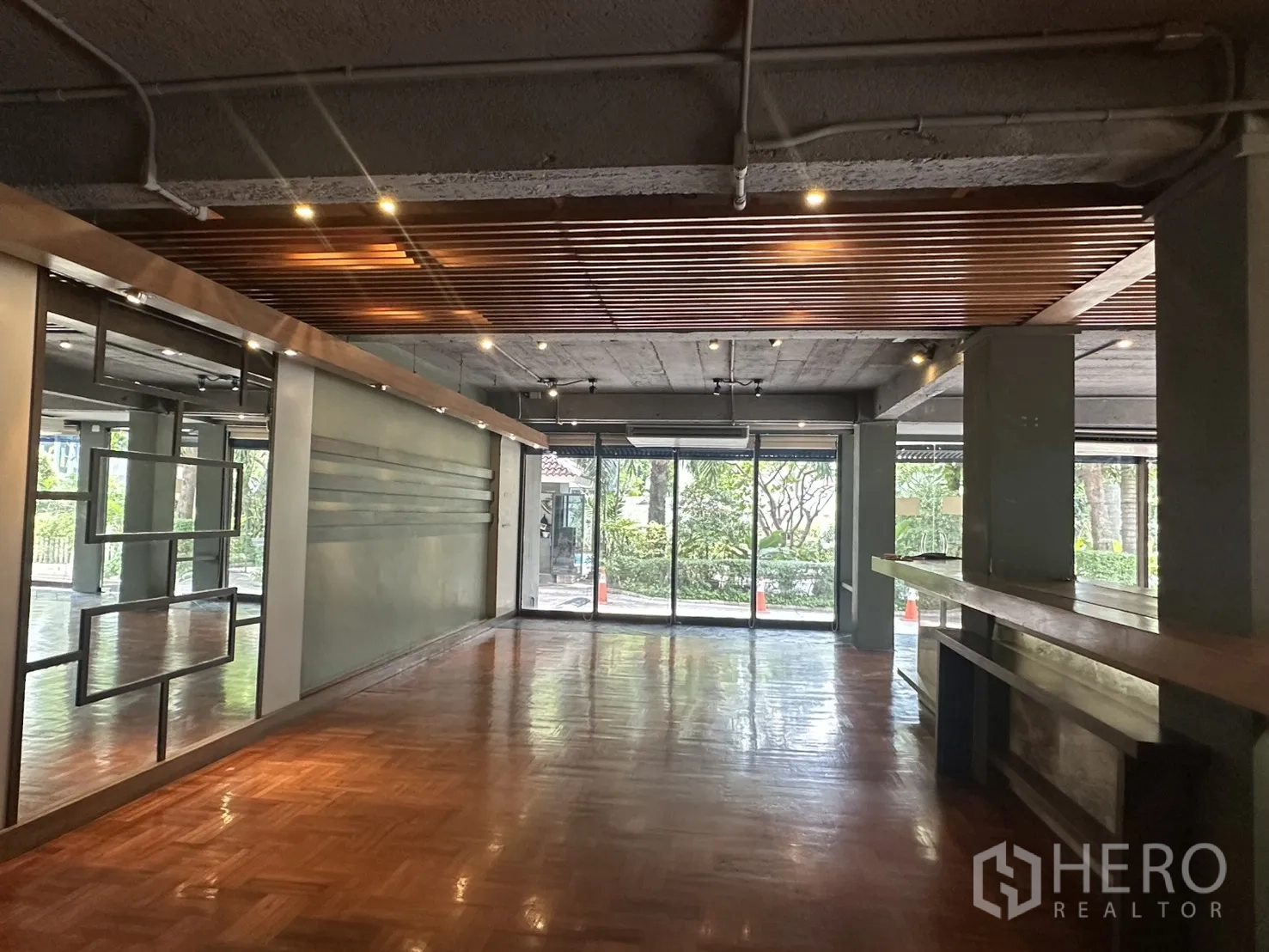 零售空间 for rent in Watthana, Bangkok - 开放式零售区，抛光木地板、特色天花与全落地玻璃门面。
