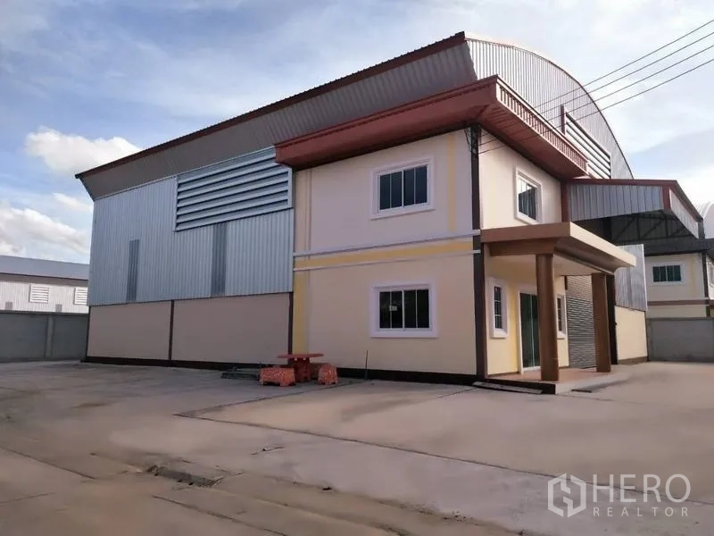 Warehouse for rent or sale in Nakhon Pathom - Side elevation of warehouse showing office block, ventilation louvres and large concrete yard.