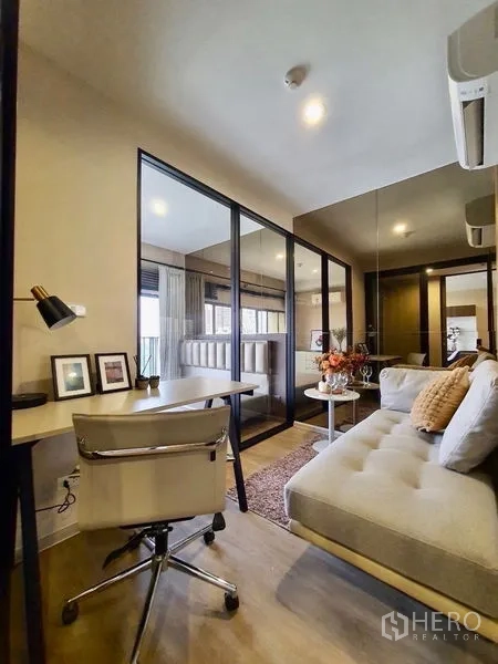 Condominium for rent in Pathum Wan, Bangkok - Study nook with desk and chair facing a glass-partitioned multipurpose room.