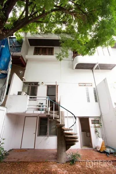 ทาวน์เฮาส์ ให้เช่าในKhlong Toei, Bangkok - ด้านหลังทาวน์เฮ้าส์สีขาวพร้อมบันไดเวียนและต้นไม้ใหญ่ในย่านทองหล่อ