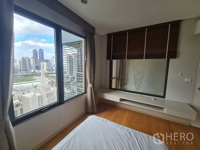 公寓 出售在Ratchathewi, Bangkok - 转角卧室，白天可见曼谷天际线与面向客厅的内窗