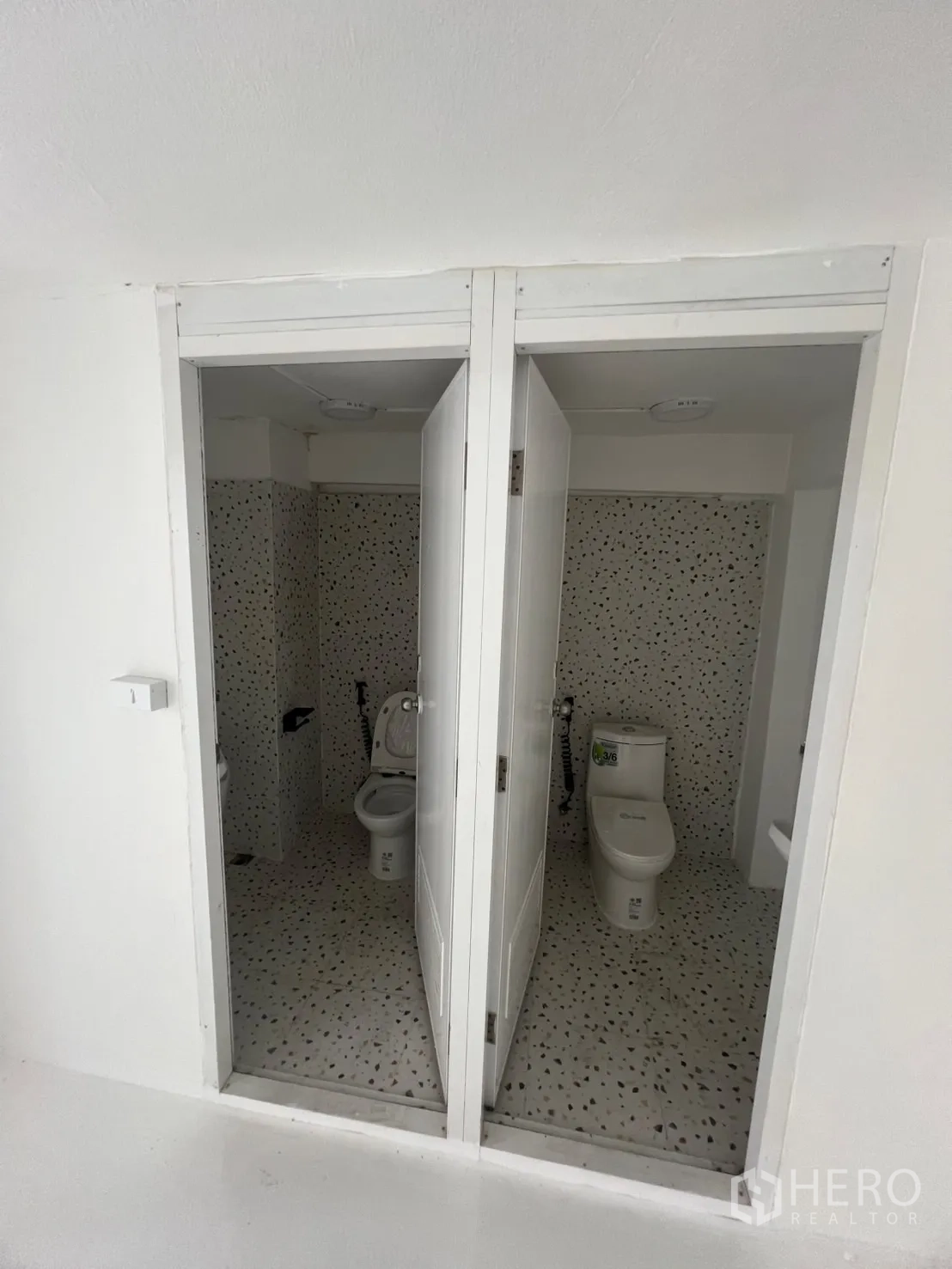 Retail Space for rent in Khlong Toei, Bangkok - Two tiled restrooms with modern toilets and terrazzo-style flooring.