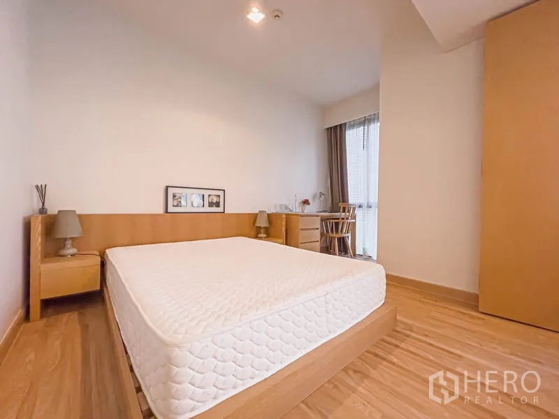 公寓 出售在Watthana, Bangkok - 温馨卧室，大床、床头柜，靠窗书桌与衣柜。