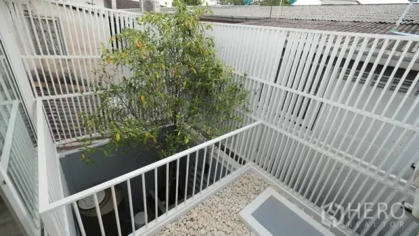 ทาวน์เฮาส์ ให้เช่าในKhlong Toei, Bangkok - คอร์ทยาร์ดเปิดโล่งมีต้นไม้ ระแนงสีขาว และสวนกรวด
