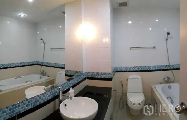 Condominium for rent in Khlong Toei, Bangkok - Modern bathroom with bathtub, handheld shower, vessel sink and mosaic tile accents.