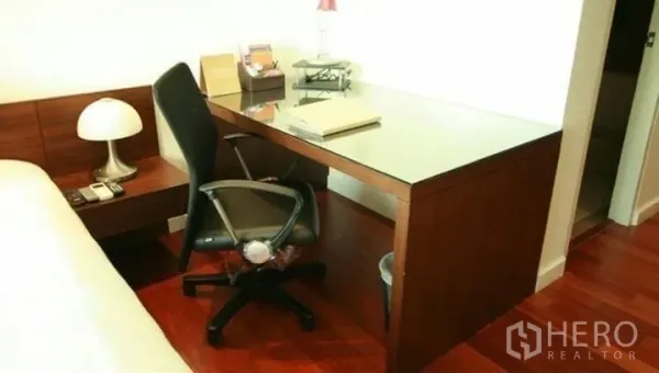 Condominium for rent or sale in Watthana, Bangkok - Built-in work desk with chair in the bedroom on polished wood flooring.