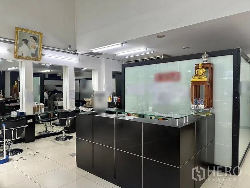 Shophouse for rent in Phra Khanong, Bangkok - Ground-floor salon reception with black counter, mirrors and stylist chairs in a shophouse setting.