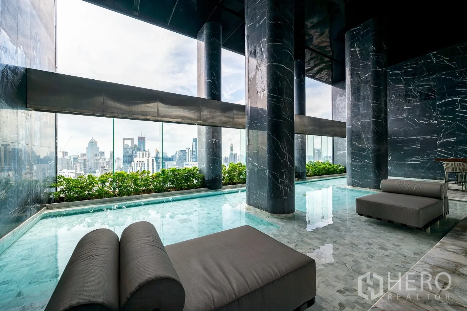 Condominium for rent in Watthana, Bangkok - Sky pool with dark marble columns and panoramic city views.