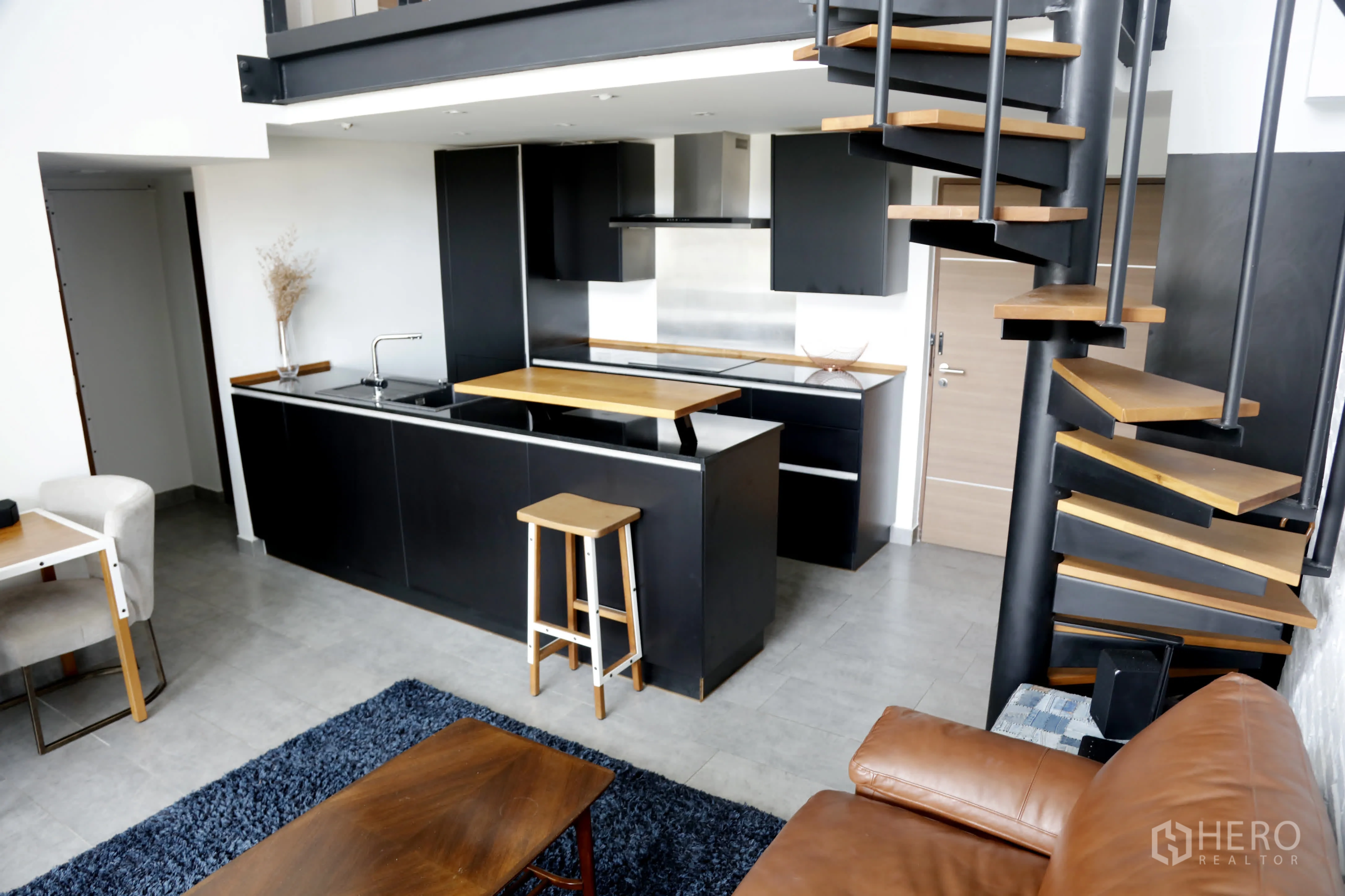 คอนโด for rent in Watthana, Bangkok - มุมมองกว้างของครัวโทนดำและบันไดวนใกล้ประตูเข้า