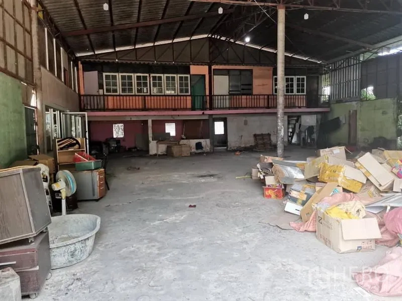 Warehouse for rent in Lam Luk Ka, Pathum Thani - Spacious warehouse interior with high steel roof, concrete floor, and mezzanine offices with storage boxes on the side.