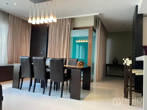 公寓 出租在Khlong Toei, Bangkok - 餐厅配六张黑色皮椅与吊灯，推拉玻璃门通向封闭阳台，旁设吧台。
