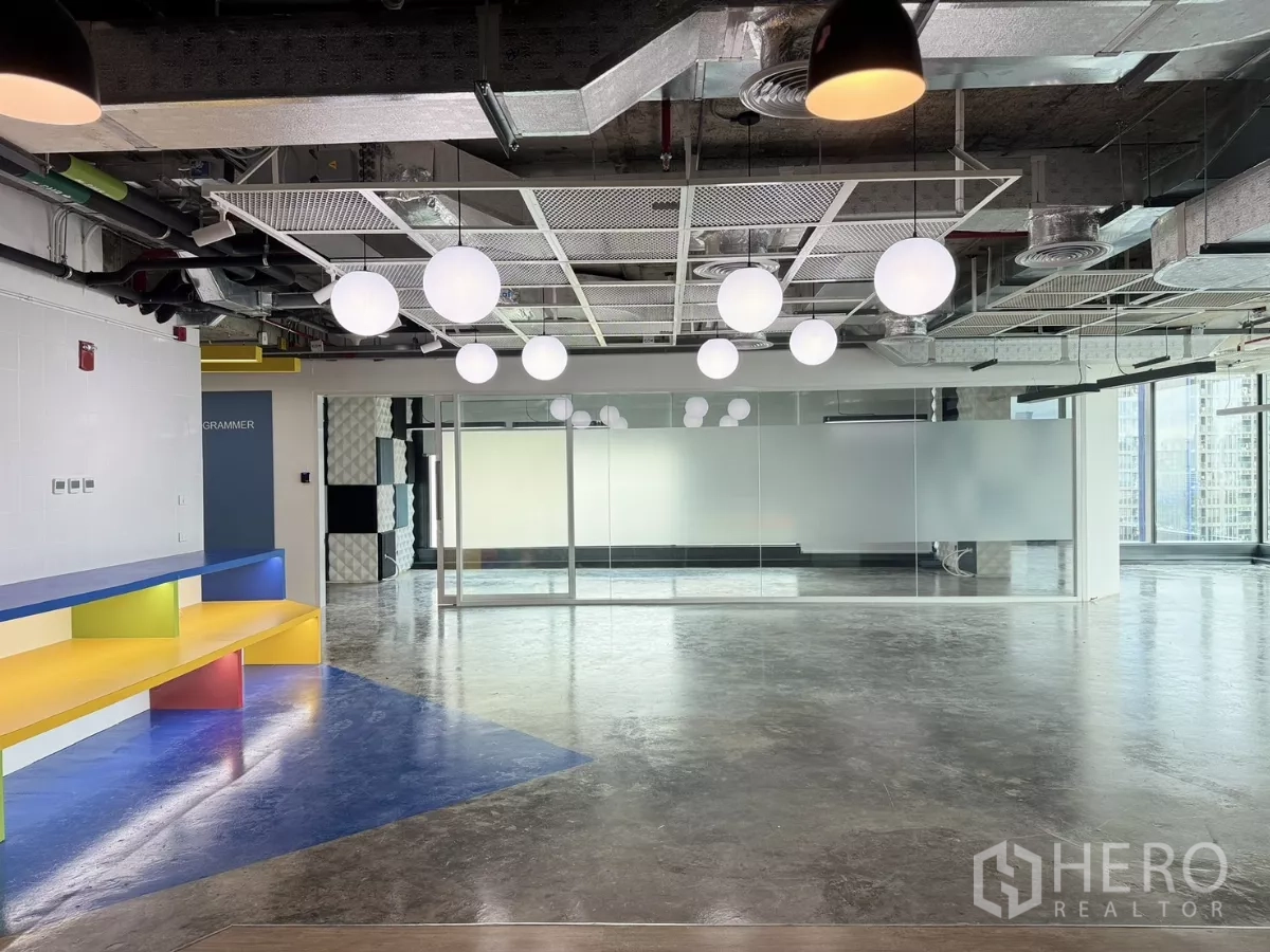 Office Space for rent in Din Daeng, Bangkok - Spacious workspace with globe pendant lights, colorful built-in bench, and a glass-wall meeting area.