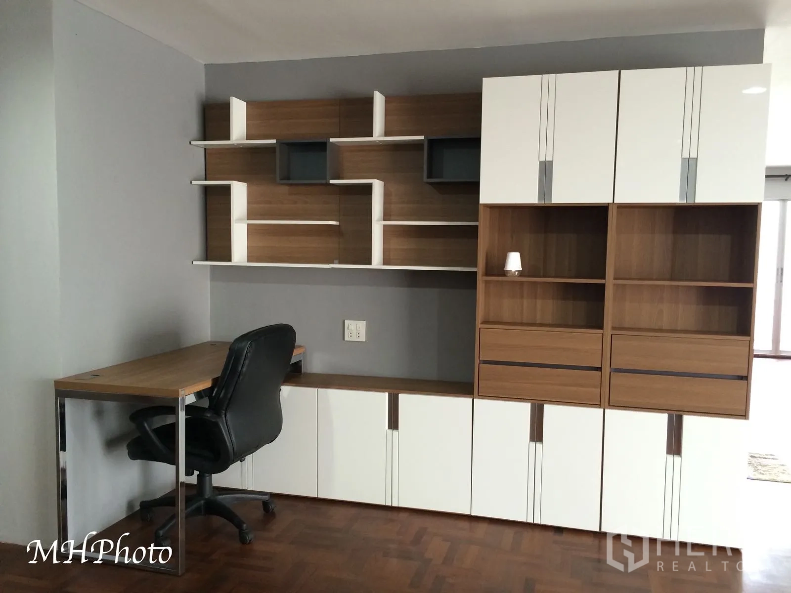 Condominium for rent in Watthana, Bangkok - Built-in home office corner with desk and ample shelving in wood and white finishes.
