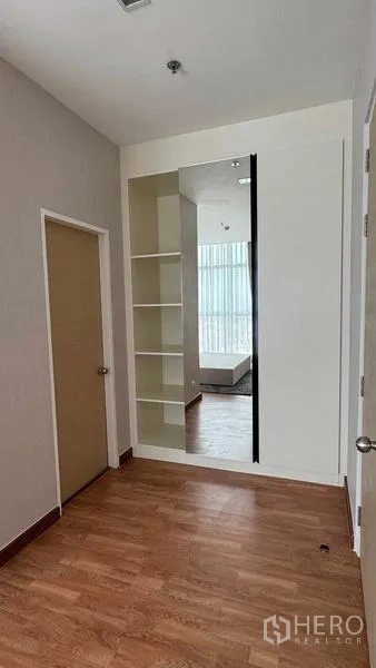 公寓 出租在Bang Na, Bangkok - 走廊或更衣角落，通顶大镜与开放式隔板，木地板干净利落。