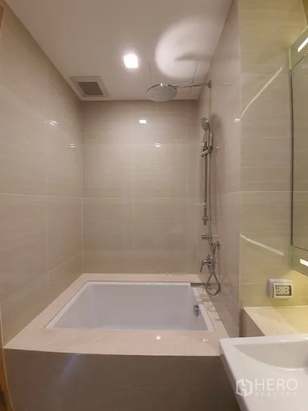 公寓 出租在Watthana, Bangkok - 现代浴室，米色瓷砖配浸泡浴缸与顶喷花洒。