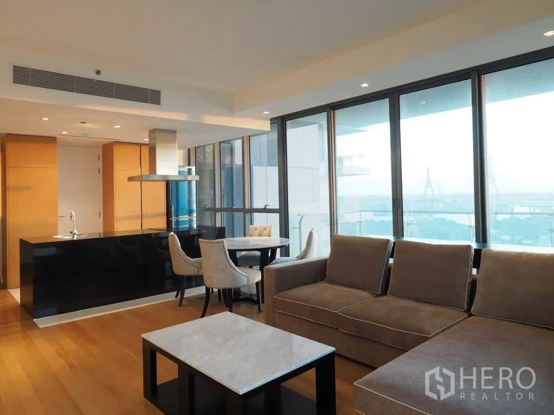 คอนโด ให้เช่าในYan Nawa, Bangkok - ห้องนั่งเล่นกว้าง โซฟาเข้ามุม ทางออกสู่ระเบียง และกระจกสูงจรดเพดาน