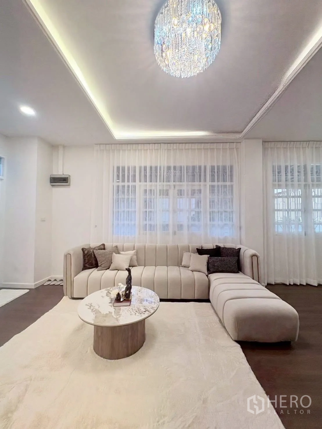 ทาวน์เฮาส์ for rent in Huai Khwang, Bangkok - ห้องนั่งเล่นโซฟา L ตัวใหญ่ โต๊ะกลางกลม และโคมไฟคริสตัล