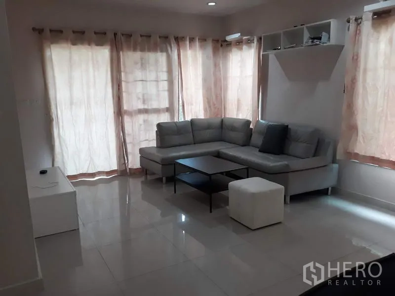 บ้าน ให้เช่าในSuan Luang, Bangkok - ห้องนั่งเล่นสว่าง โซฟาเข้ามุมสีเทา พื้นกระเบื้องเงา