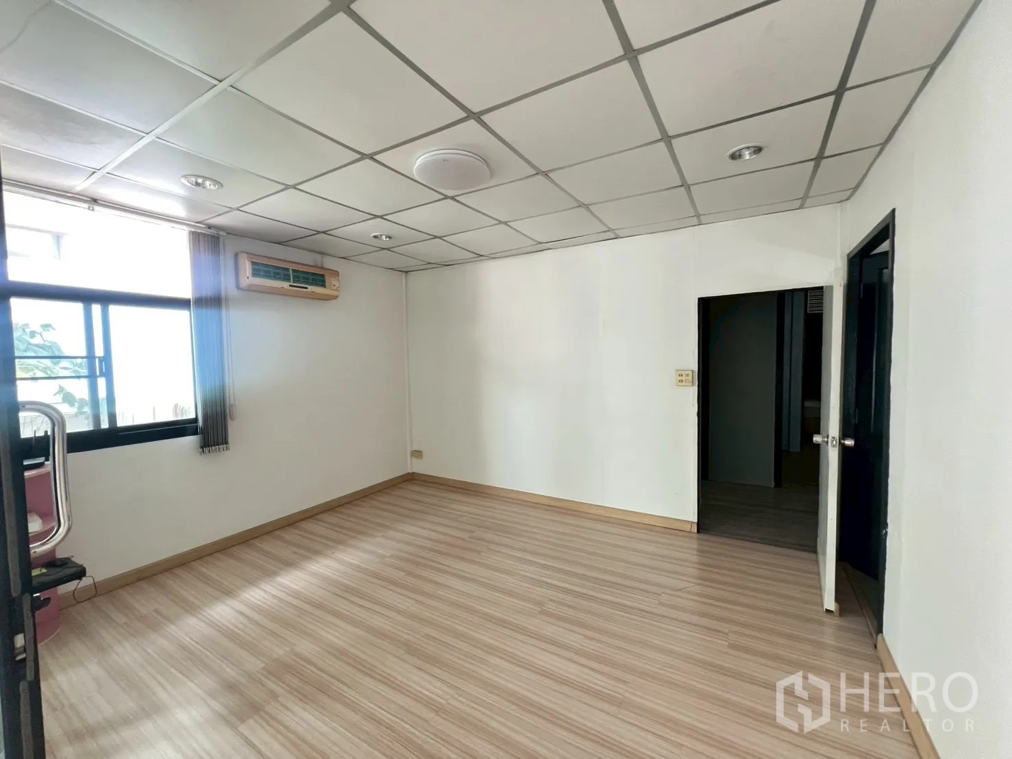 Detached House for rent or sale in Wang Thonglang, Bangkok - Spacious multipurpose room with drop ceiling, window and wood‑look floor.