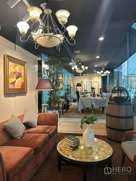 Retail Space for rent - Cozy corner with sofa, round coffee table and chandeliers beside floor-to-ceiling glass.