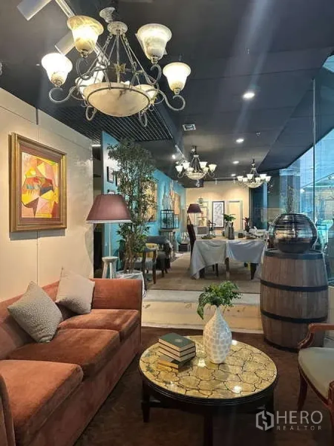 Retail Space for rent - Cozy corner with sofa, round coffee table and chandeliers beside floor-to-ceiling glass.