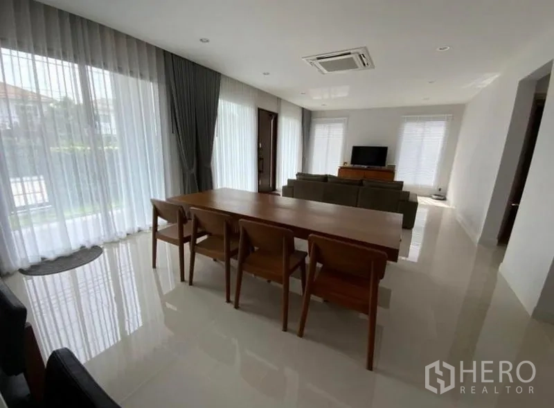 Detached House for rent - Spacious living–dining area with a long wooden dining table and large windows.