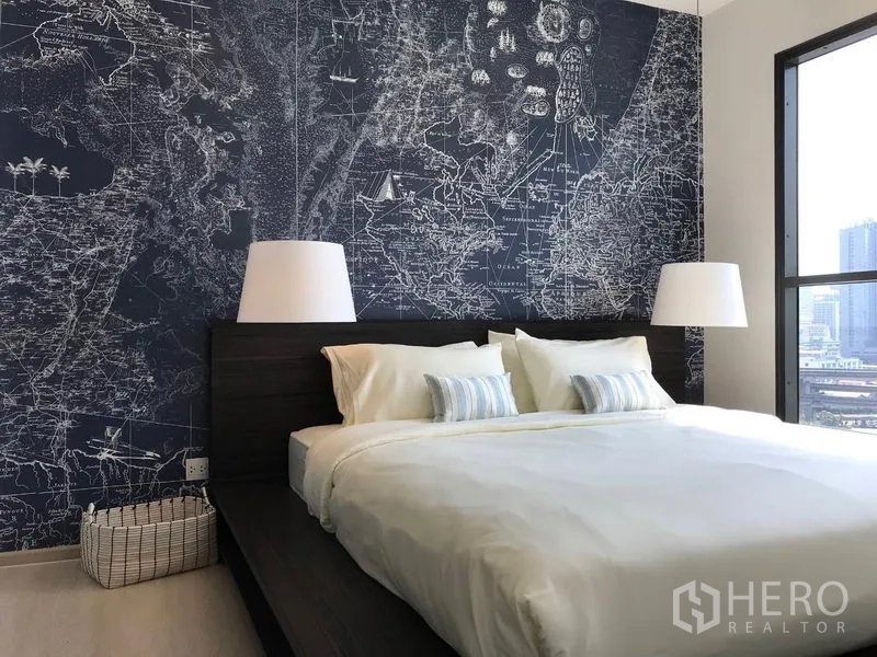 Condominium for rent in Khlong Toei, Bangkok - Master bedroom with king bed, map feature wall, and wide windows overlooking Bangkok.