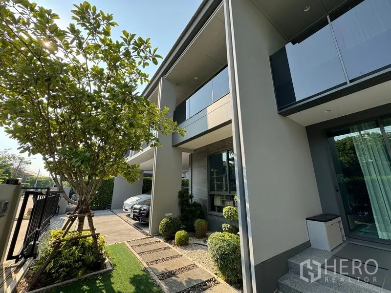 Detached House for rent in Bang Kapi, Bangkok - Side garden with mature tree, stepping-stone path and carport beside the house.
