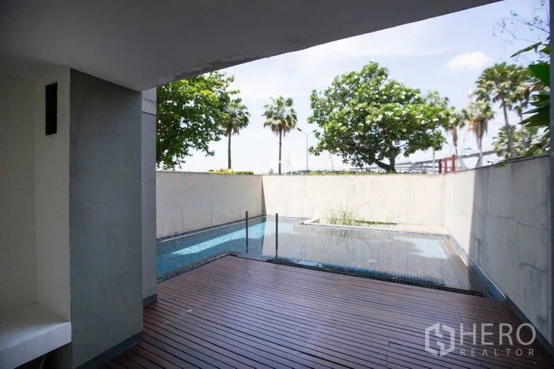 Condominium for rent in Yan Nawa, Bangkok - Outdoor deck with private plunge pool, privacy wall and trees beyond.