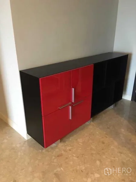 Condominium for rent in Khlong Toei, Bangkok - Contemporary red and black storage cabinet on a stone floor.