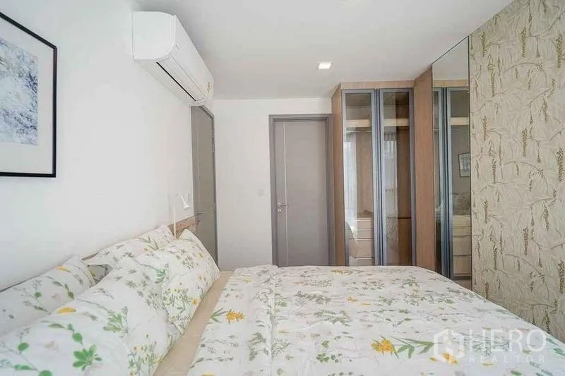 公寓 出租在Watthana, Bangkok - 主卧，花卉床品与走廊一侧衣柜。