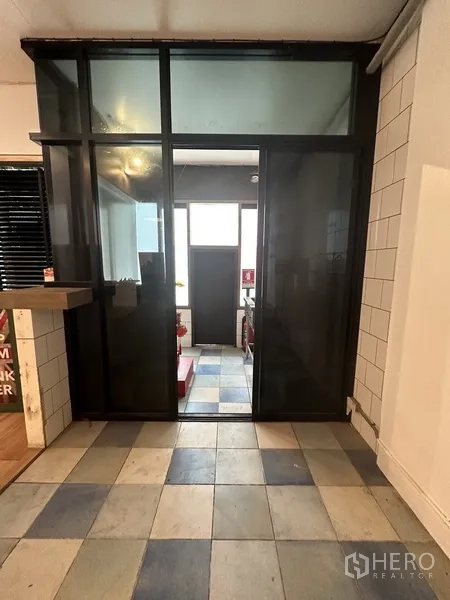 带办公室的家 出租在Watthana, Bangkok - 黑框玻璃滑门通向功能间，地面为瓷砖。
