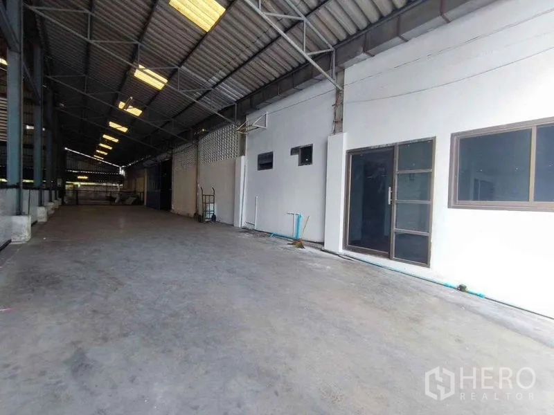 Warehouse for rent in Samut Sakhon - Covered loading bay with metal roof and access to office entry for all‑weather operations.