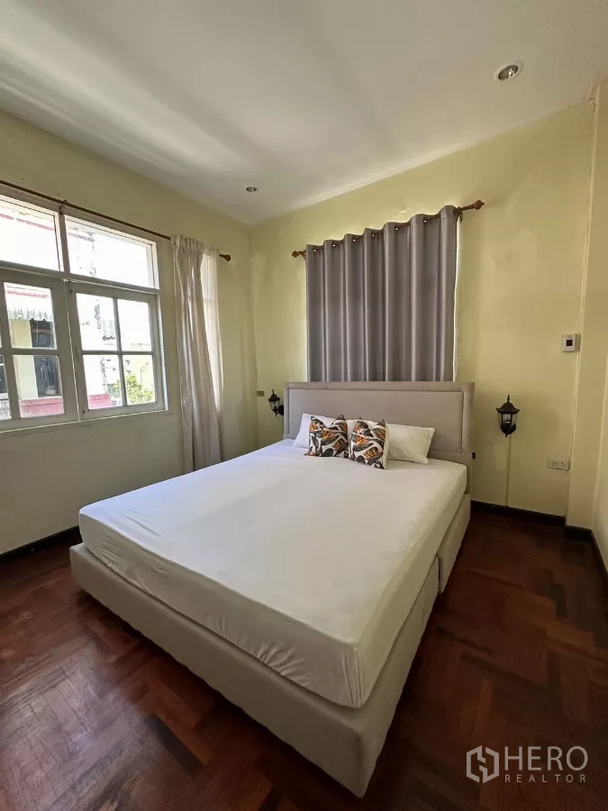 带办公室的家 出租在Suan Luang, Bangkok - 采光卧室，软包床与灰色窗帘。