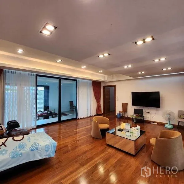 独立式住宅 出售在Phra Khanong, Bangkok - 宽敞客厅，实木地板、筒灯与壁挂电视