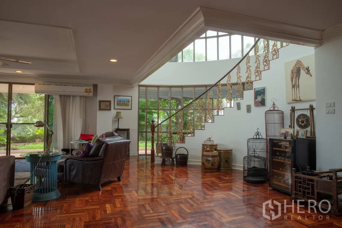 อพาร์ทเมนท์ for rent in Khlong Toei, Bangkok - มุมนั่งเล่นพื้นไม้มันวาว เก้าอี้หนัง และบันไดโค้ง.