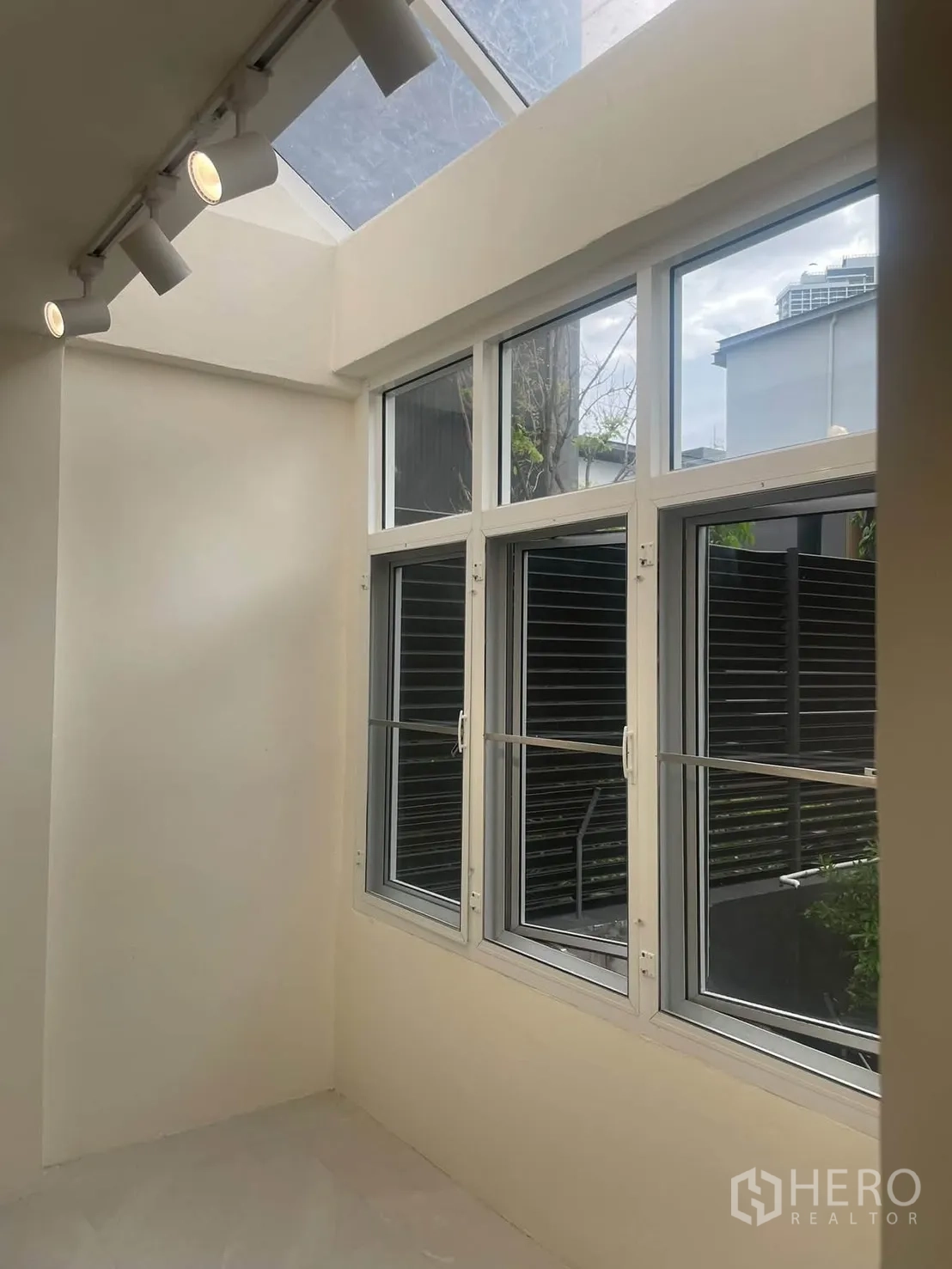 Townhouse for rent in Huai Khwang, Bangkok - Sunlit corner with skylight roof, track lighting, and white-framed windows.