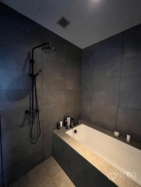 公寓 出租在Watthana, Bangkok - 深色瓷砖墙面的浴缸与顶喷花洒