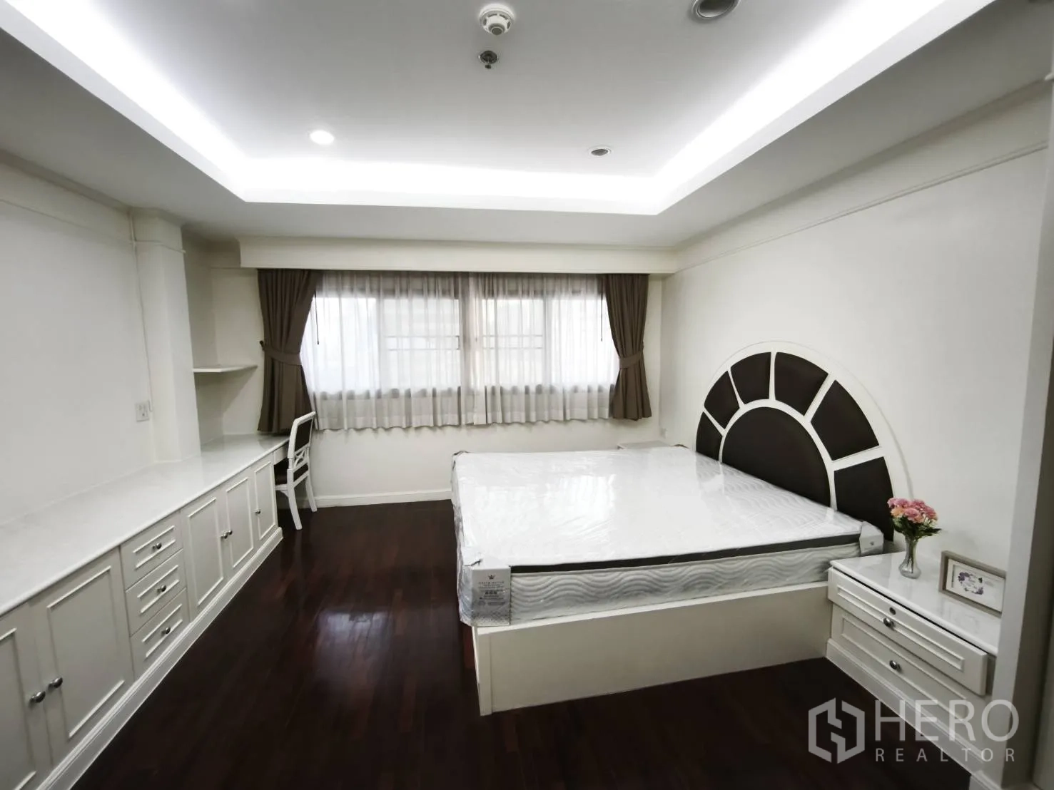 คอนโด for rent in Watthana, Bangkok - ห้องนอนหลักมีโต๊ะทำงานและตู้บิลท์อิน เตียงหัวเตียงดีไซน์โค้ง และหน้าต่างบานกว้าง